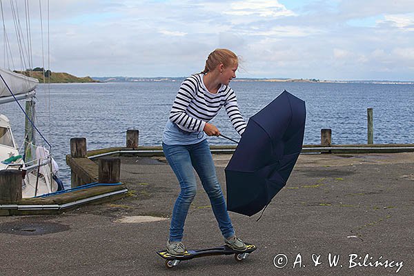 Zabawa na deskorolce z parasolką, port Korshavn, wyspa Avernako, Archipelag Południowej Fionii, Dania