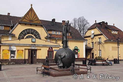 Rabka, pomnik św. Mikołaja Biskupa przed zabytkowym budynkiem Dworca PKP