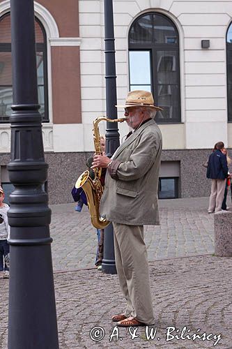 Ryga, uliczny muzykant na placu Ratuszowym na tle Domu Bractwa Czarnogłowych, saksofonista, Stare Miasto, Łotwa