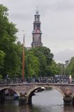 Wieża kościoła i rowery na moście nad kanałem, Amsterdam, Holandia