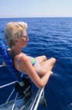 Kobieta siedząca na koszu dziobowym jachtu, Grecja