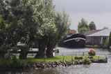na kanale w drodze z Goudy do Amsterdamu, barka i wierzby na polderze, Holandia