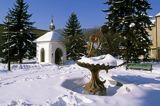 Muszyna, rynek zimą, fontanna i kapliczka św. Floriana