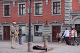 Ryga, uliczny muzykant na placu Ratuszowym na tle Domu Bractwa Czarnogłowych, Stare Miasto, Łotwa